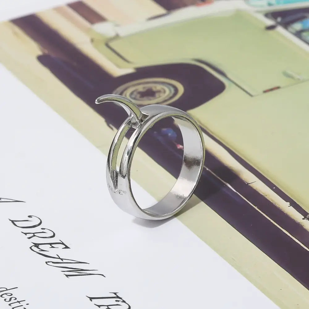Silver-toned annie leonhart ring with sleek minimalist design featuring two interlocking curved bands and crescent accent