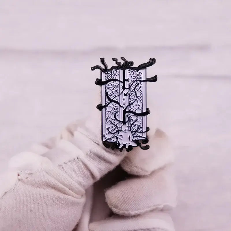 Black and silver enamel pin with detailed sword and branch design featuring fullmetal alchemist edward elric