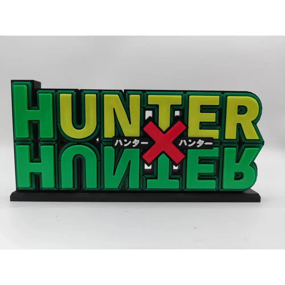 Hunter x hunter logo stand in green and yellow 3d print with red x and japanese text on black base