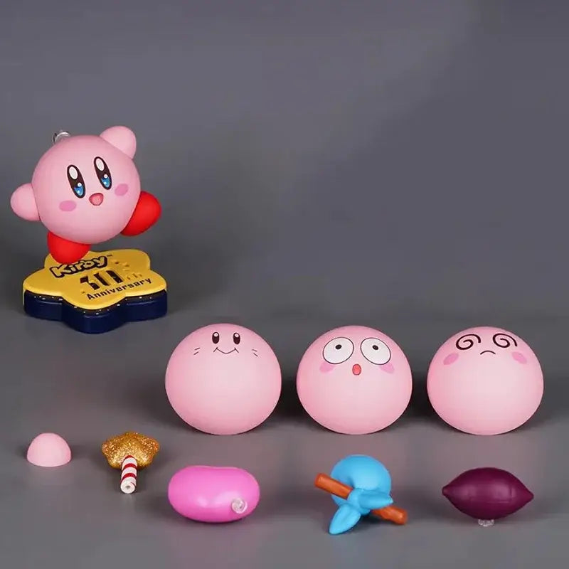 Pink kirby pvc figure with red arms and blue eyes standing on yellow and navy base 30th anniversary edition collectible