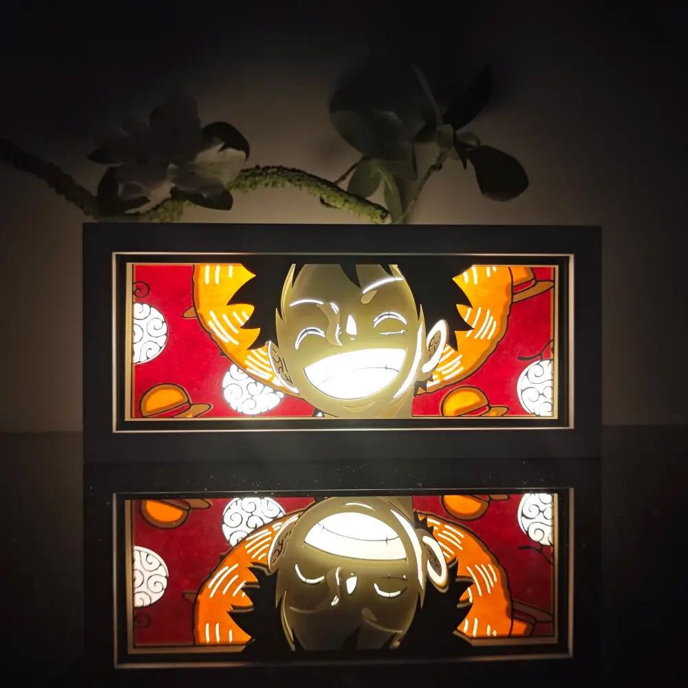 Anime 3d paper carved lamp featuring a glowing led light box of luffy with spiky hair and joyful expression on red background