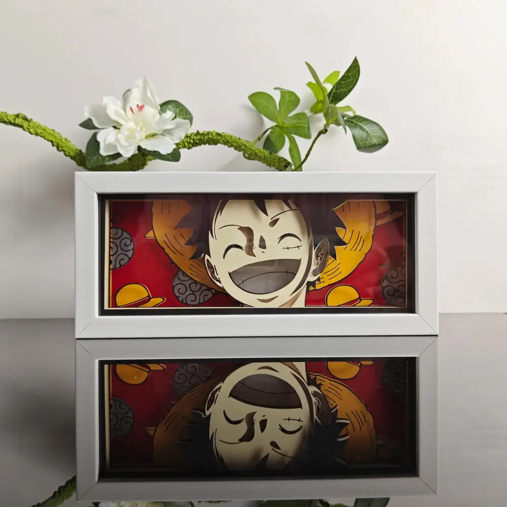 White framed anime 3d paper carved lamp featuring a smiling black haired character with orange hat on red background