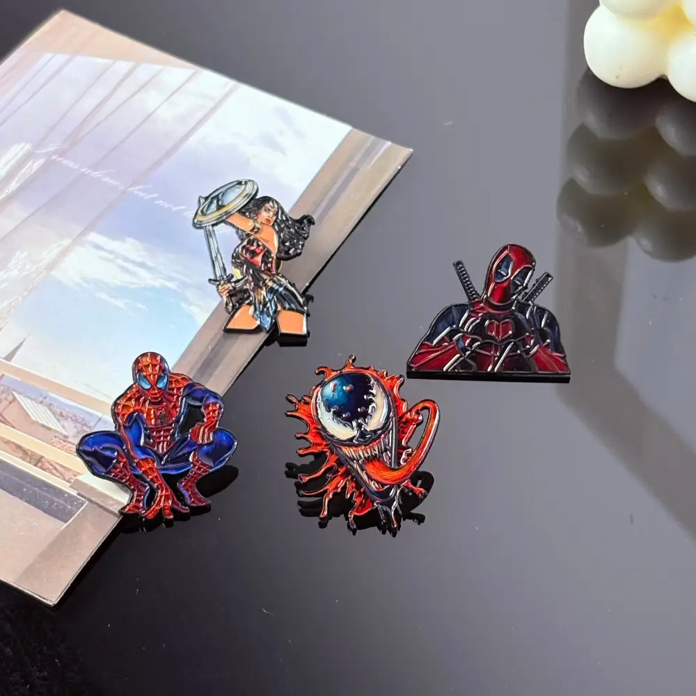 Set of four colorful metal enamel pins featuring marvel characters including spider-man venom deadpool and wonder woman anime badge