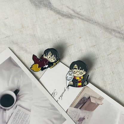 Two anime boy enamel pins featuring a flying boy in maroon robes with broomstick and holding an owl and wand