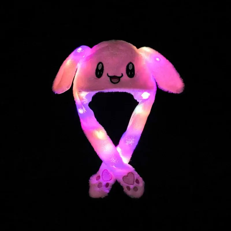 Pink soft plush bunny hat with glowing led ears and long crossed straps ending in paw-shaped feet for cosplay