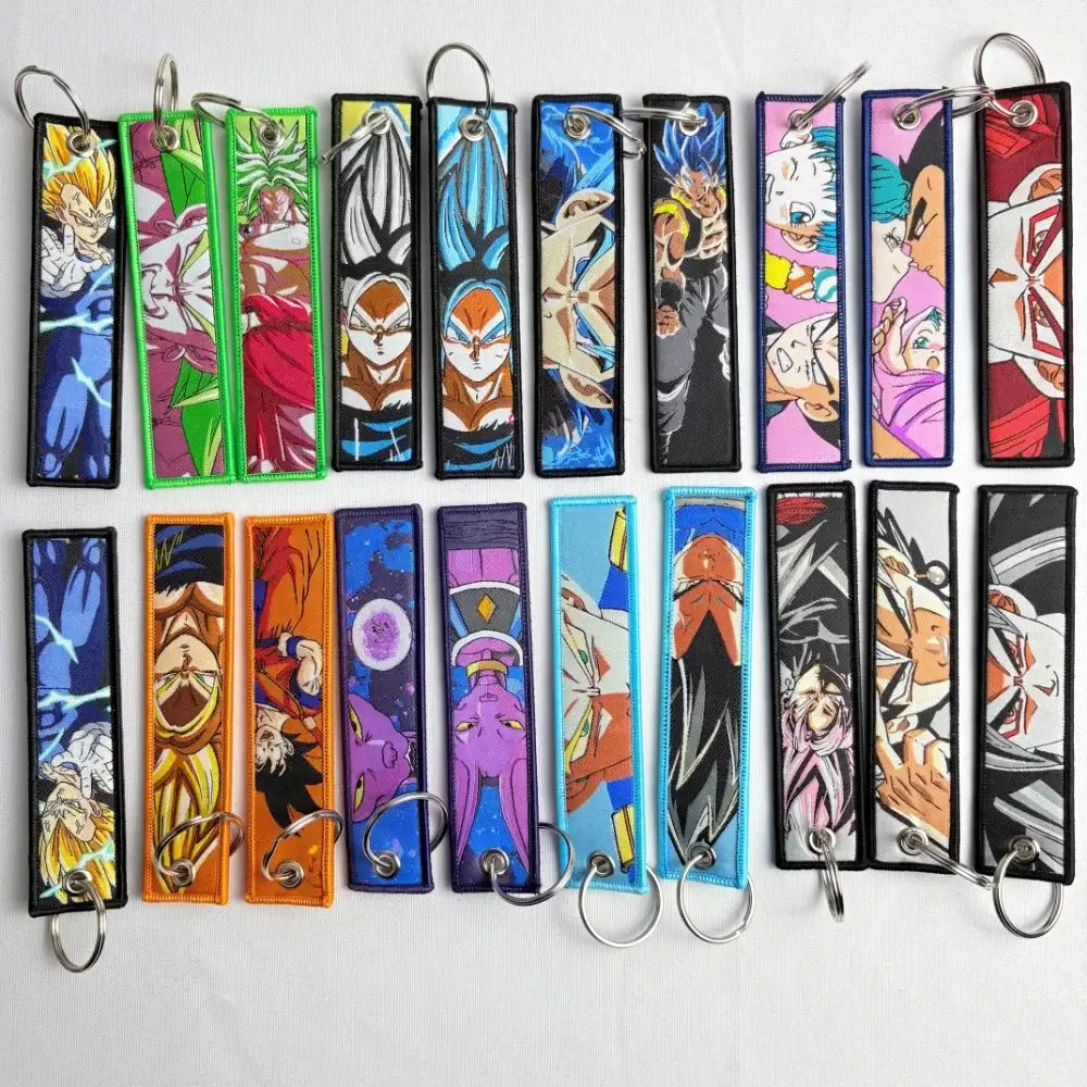 A collection of colorful embroidered dragon ball z anime key fob key tags on fabric strips with metal rings