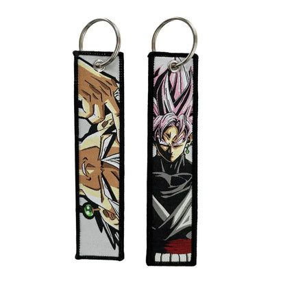 Two embroidered key fobs featuring anime characters brown haired figure and black goku with pink hair key tag keychain