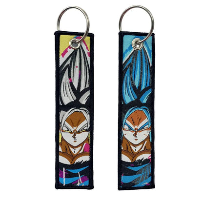 Two anime cartoon embroidery key fob key tags with spiky hair characters in yellow white and blue orange tones