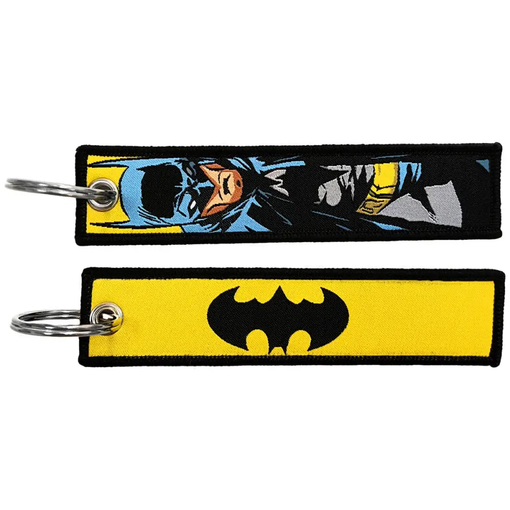Two embroidered key fobs featuring a blue and yellow batman comic-style design and a black bat symbol on yellow fabric key tag