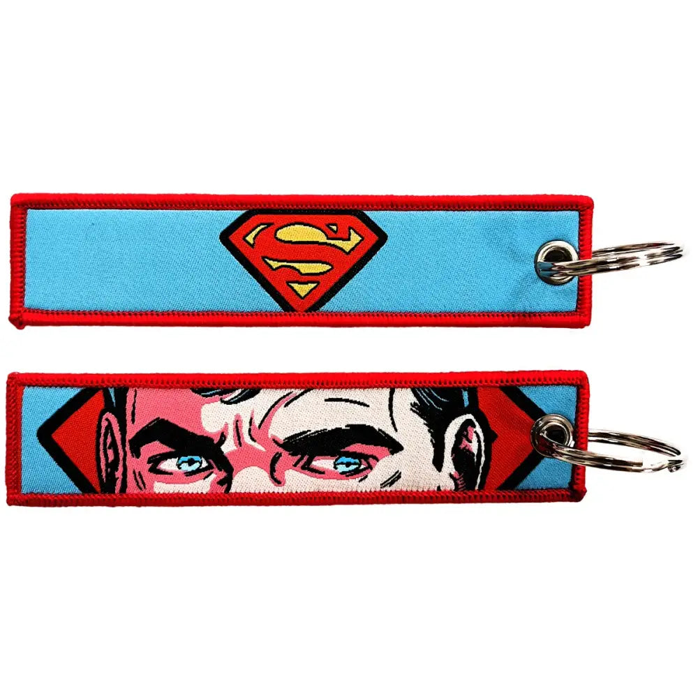 Two embroidered key fobs featuring superman designs with red yellow logo and clark kent face on key tag keychain