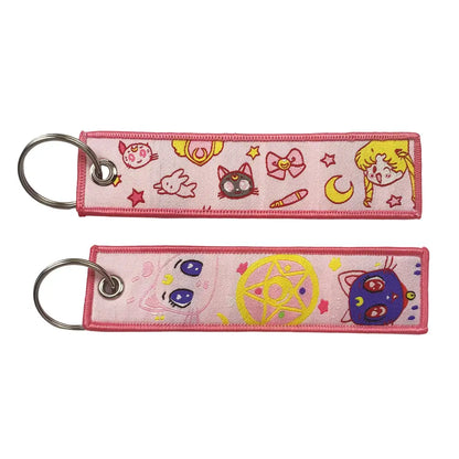 Pink embroidered key fob featuring sailor moon characters and symbols as a key tag keychain accessory
