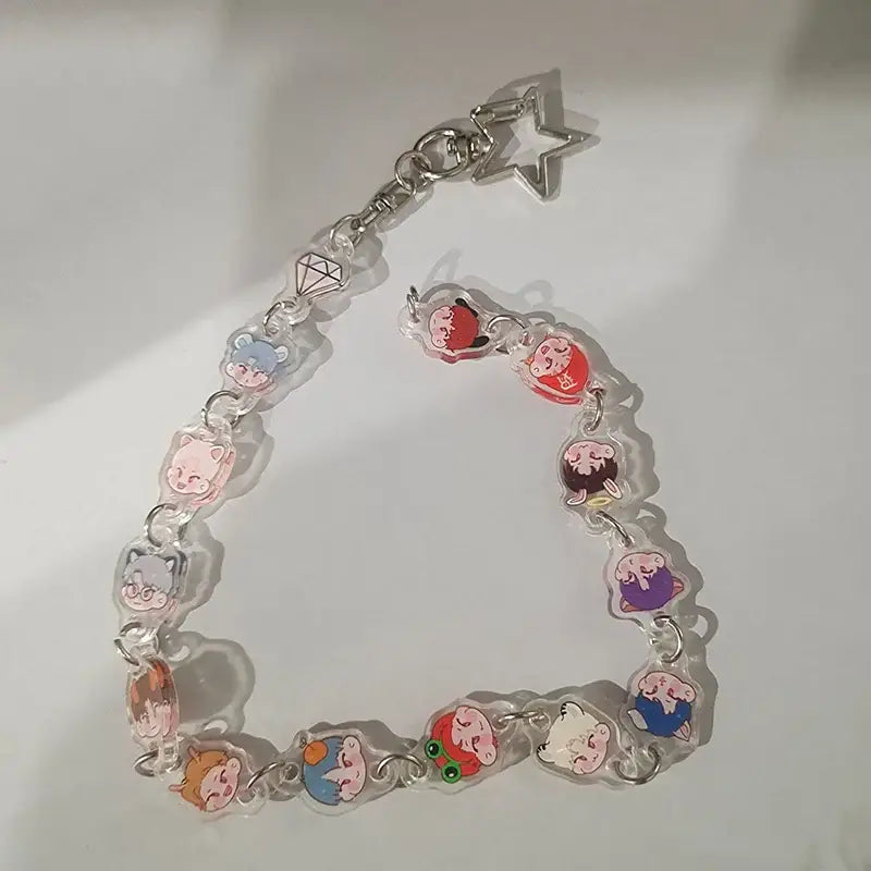 A clear acrylic anime charm bracelet keychain with colorful cartoon charms and a silver beaded star pendant clasp