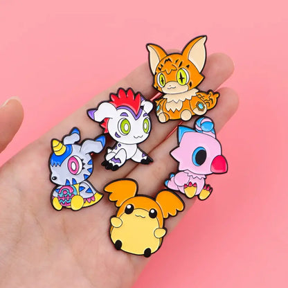 A hand holds five colorful anime elf enamel pins with cute animal designs and glossy finishes for backpacks and lapels