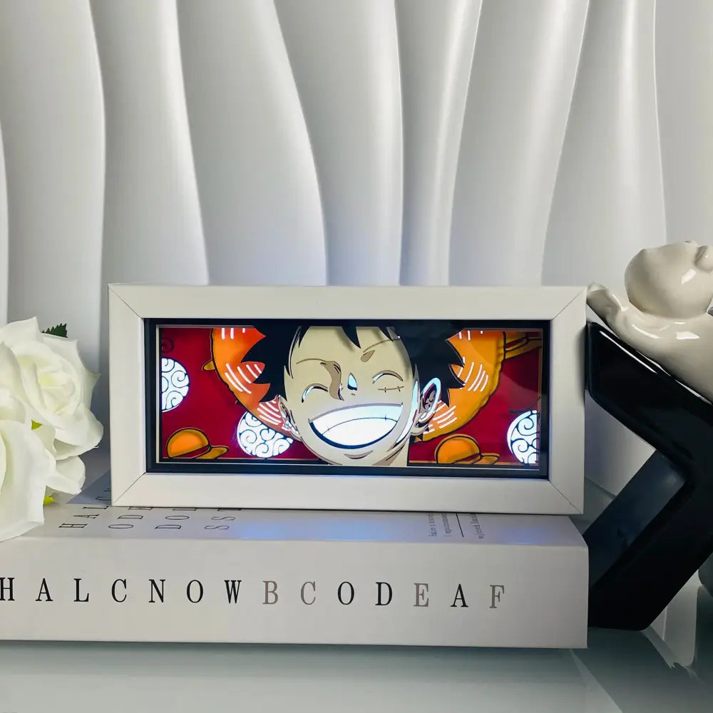 White-framed anime eyes shadow box led lamp featuring luffy with illuminated grin on red background desk lamp