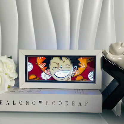 White-framed anime eyes shadow box led lamp featuring luffy with illuminated grin on red background desk lamp