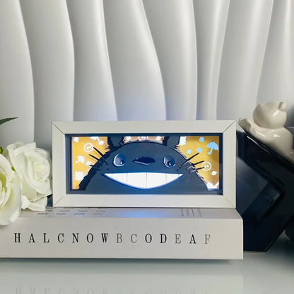 White-framed totoro led light box featuring a smiling blue character with anime eyes in a 3d paper carving design