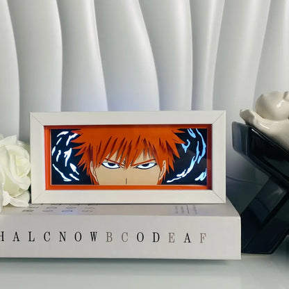 A white-framed anime eyes shadow box led lamp featuring 3d paper carving and glowing blue energy swirls around an orange-haired anime character