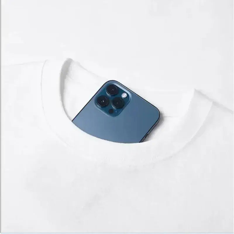 A sleek deep blue iphone 12 pro with triple-lens camera resting in the neckline of a retro streetwear anime harajuku unisex tee