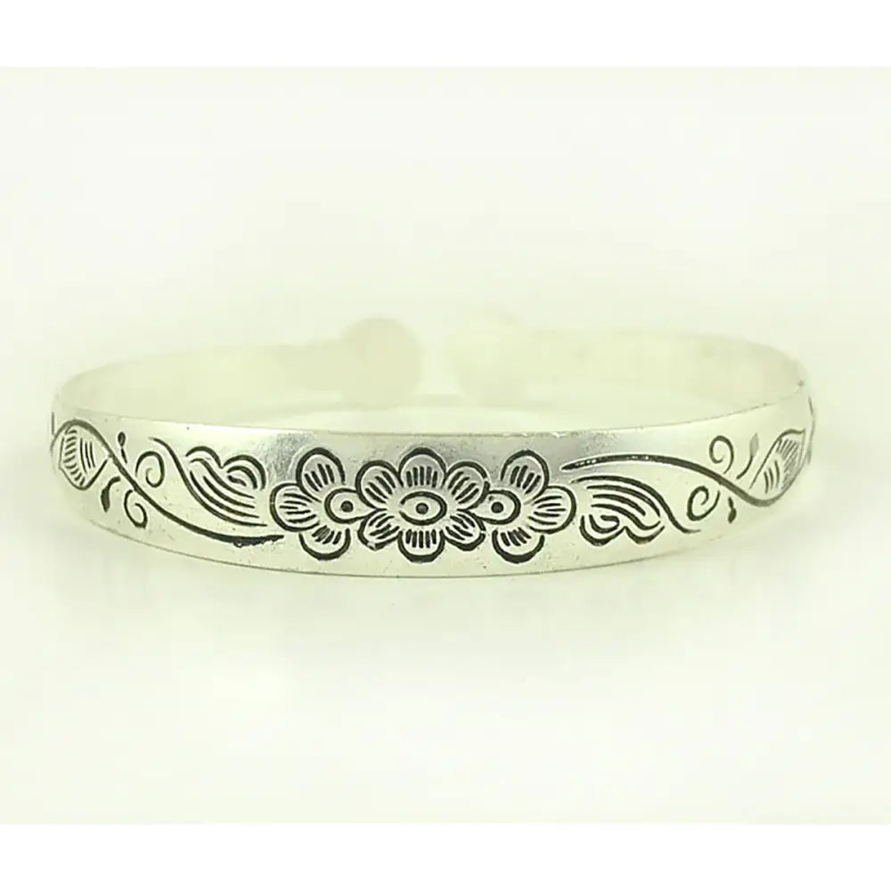 Silver-toned tibetan silver retro cuff bracelet with engraved floral design and swirling vines around central flower motif