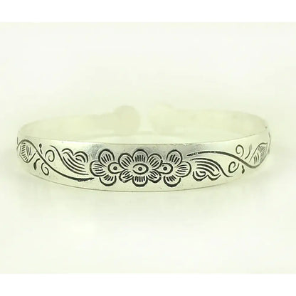 Silver-toned tibetan silver retro cuff bracelet with engraved floral design and swirling vines around central flower motif