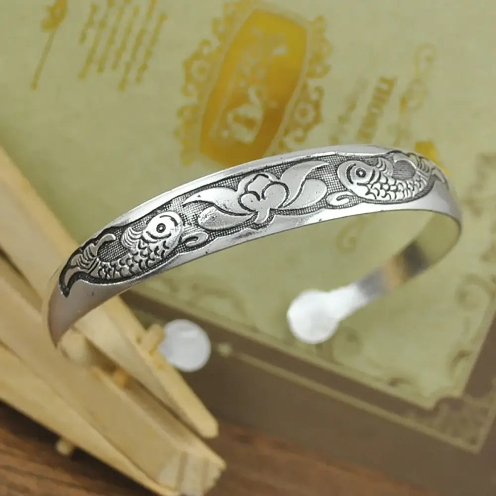 Silver tibetan silver retro open-ended cuff bracelet with carved fish and floral designs in engraved metal