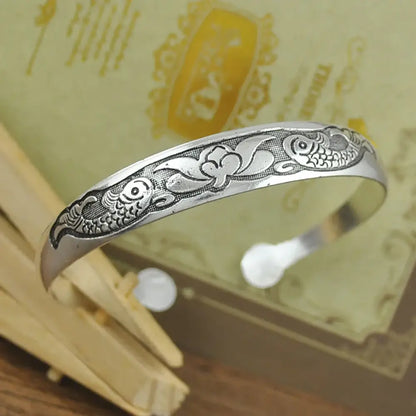 Silver tibetan silver retro open-ended cuff bracelet with carved fish and floral designs in engraved metal
