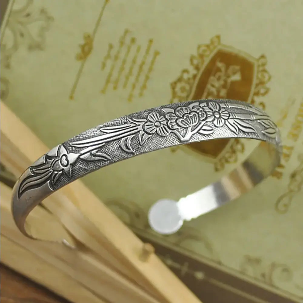 Silver-toned tibetan silver retro cuff bracelet with intricate floral and leaf engravings and polished finish