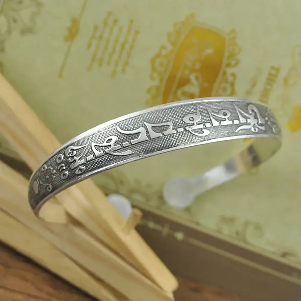 Silver-toned tibetan silver cuff bracelet with intricate engraved tibetan silver retro script and decorative motifs