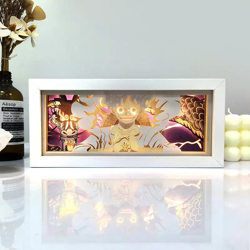White-framed anime led shadow light box featuring a golden anime character with pink and brown paper cut details