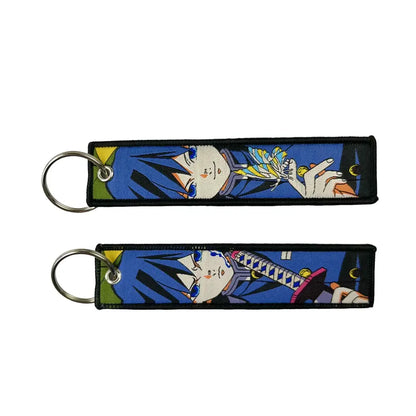 Blue embroidered anime lock keychain featuring a black haired anime character with blue eyes and butterfly and sword jet tag designs