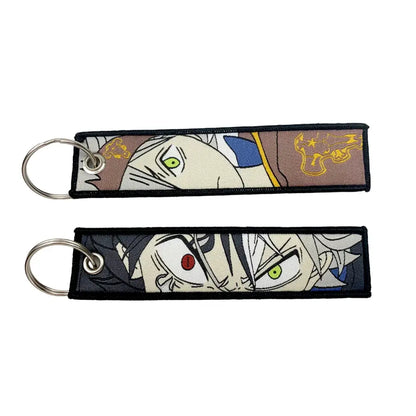 Two embroidered anime lock keychains featuring a white-haired green-eyed figure and an angry red-eyed face