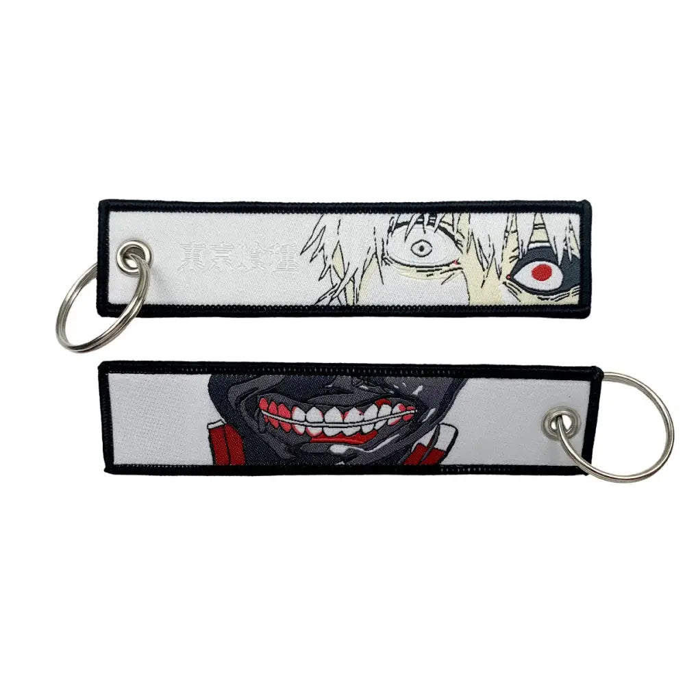 White embroidered anime lock keychain featuring black and red character designs with silver metal rings