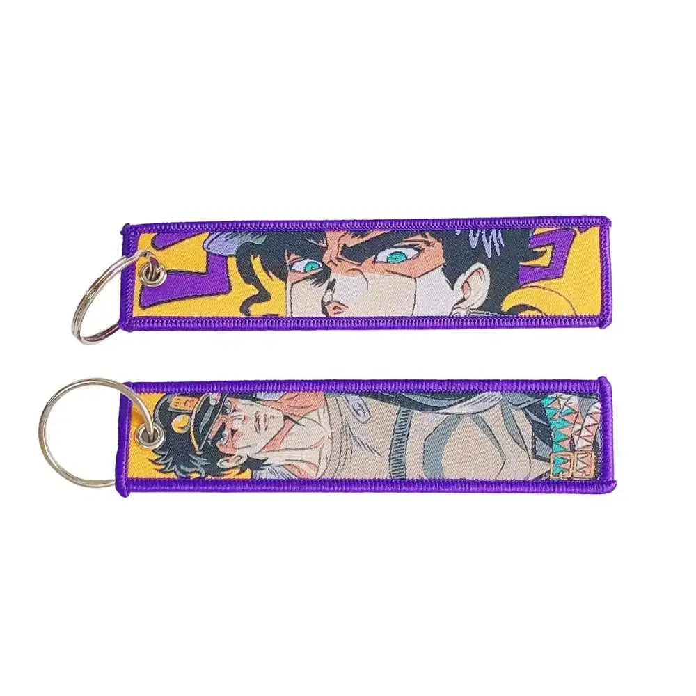 Two purple embroidered anime lock keychains featuring jojo’s bizarre adventure characters with metallic jet tag rings