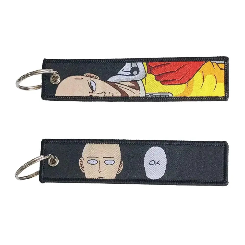 Black embroidered anime lock keychain jet tag featuring saitama sleeping and ok bubble designs from one punch man