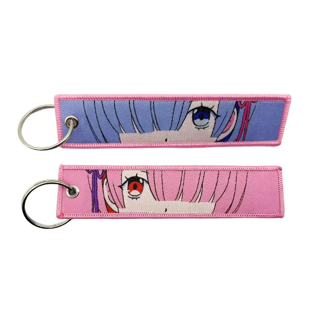 Two anime lock keychain jet tags with rectangular embroidered fabric and metal rings for secure attachment