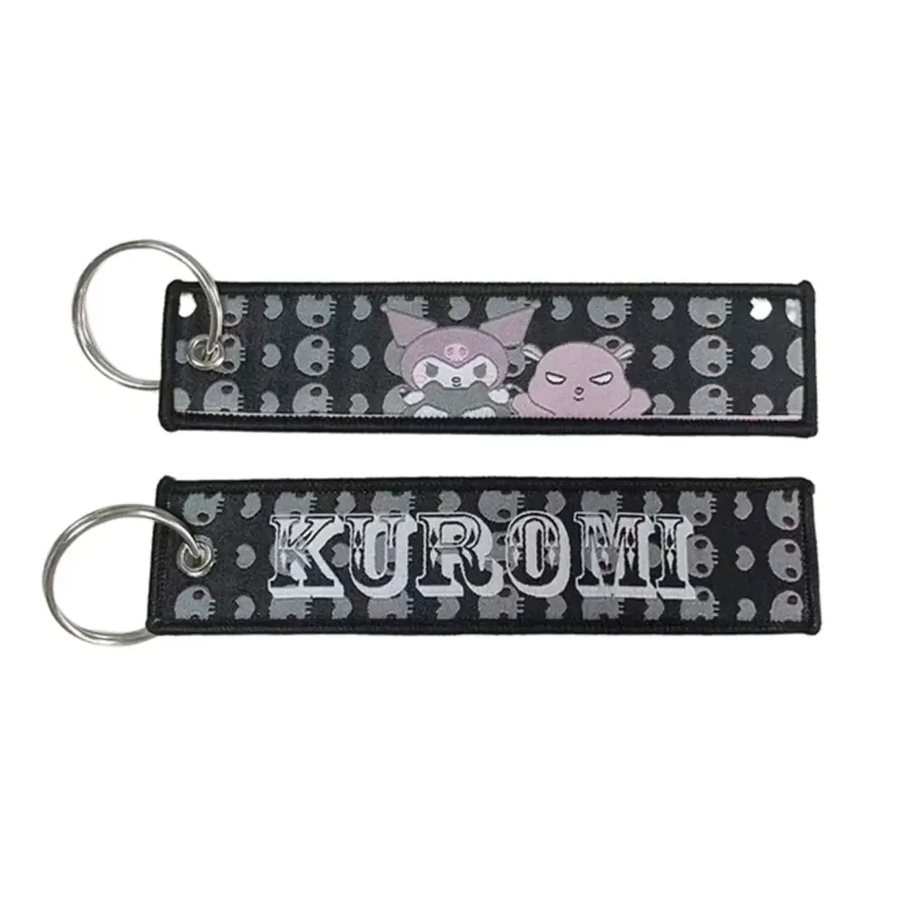 Black embroidered anime lock keychain featuring gray and pink kuromi design with white kuromi lettering on jet tag