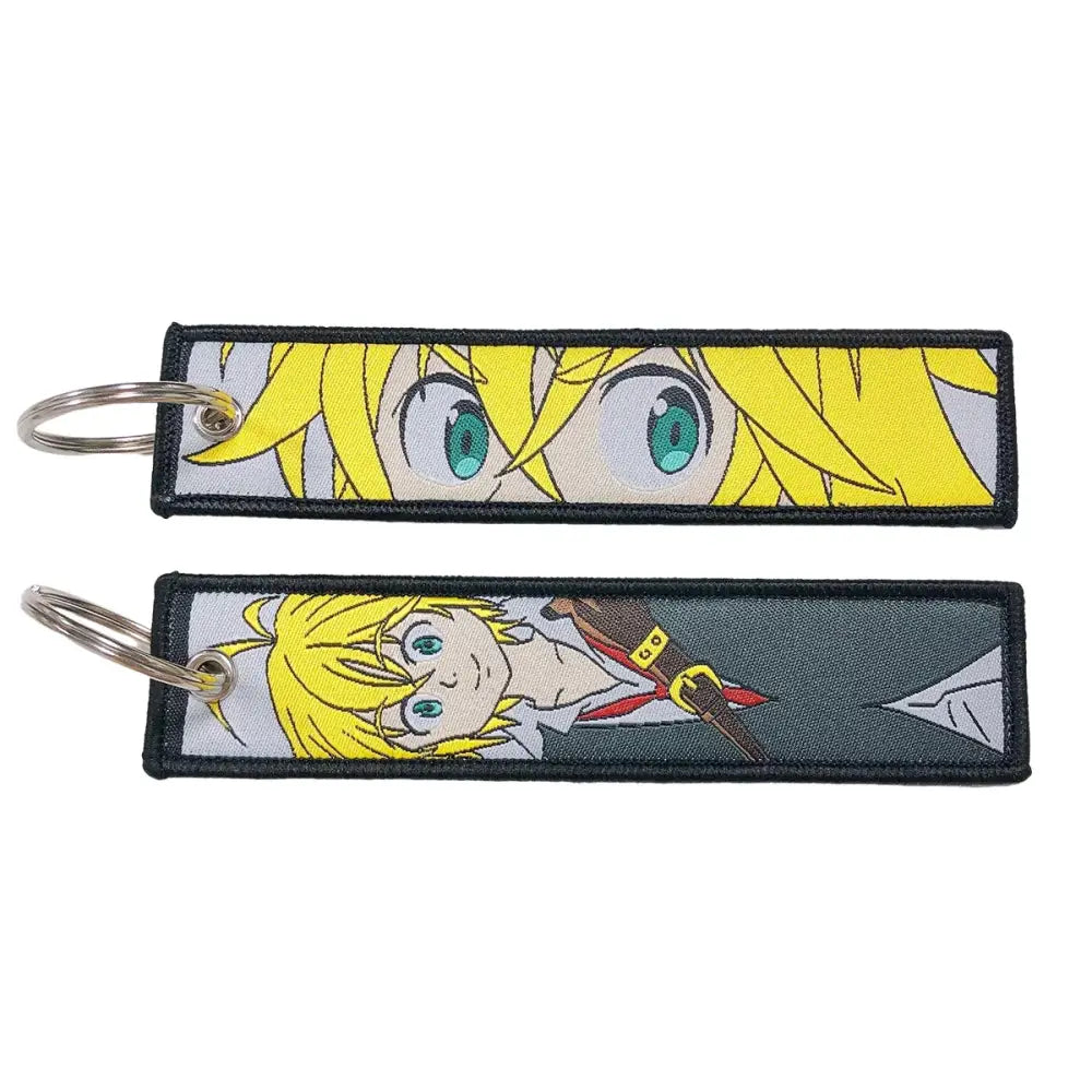 Two embroidered anime lock keychains with bright yellow hair and green eyes featuring jet tag designs
