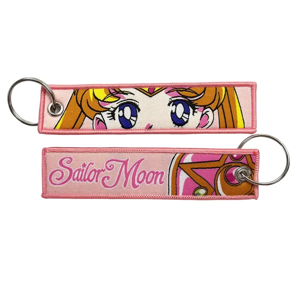 Pink embroidered anime lock keychain featuring sailor moons face and cursive logo on a jet tag lock keychain
