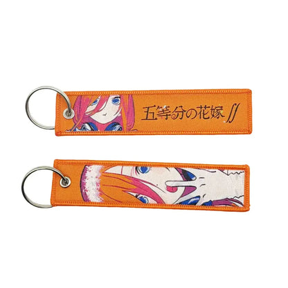 Orange embroidered anime lock keychain with pink hair anime character and black 五等分の花嫁 text design
