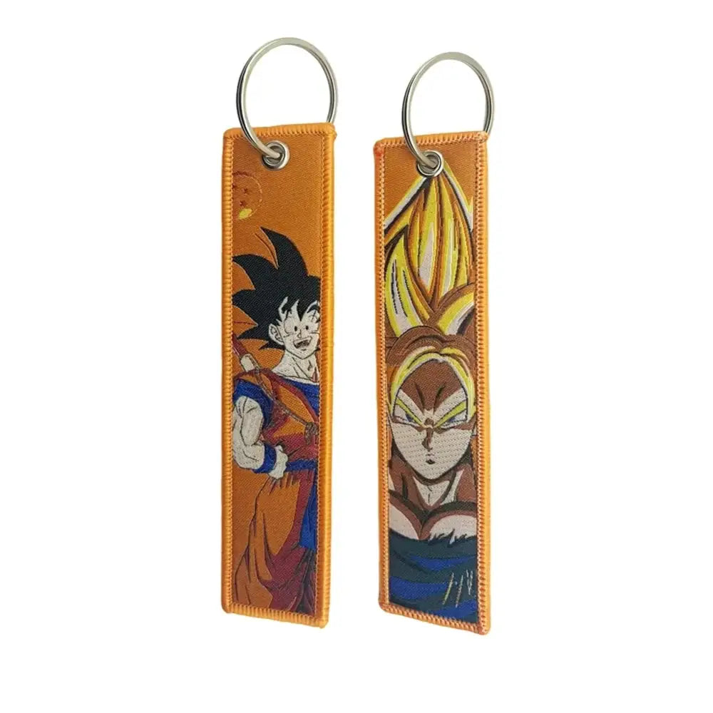 Two orange fabric anime lock keychains featuring embroidered goku in base form and super saiyan form characters