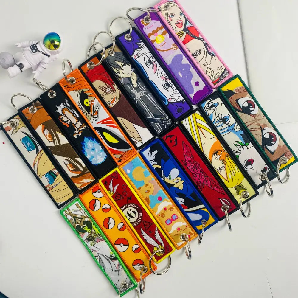 A colorful set of embroidered anime mix character jet tag keychains with fabric straps and metal rings