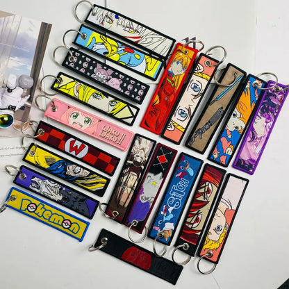 Colorful anime mix character jet tag keychain set with embroidered fabric designs and metal rings for easy attachment