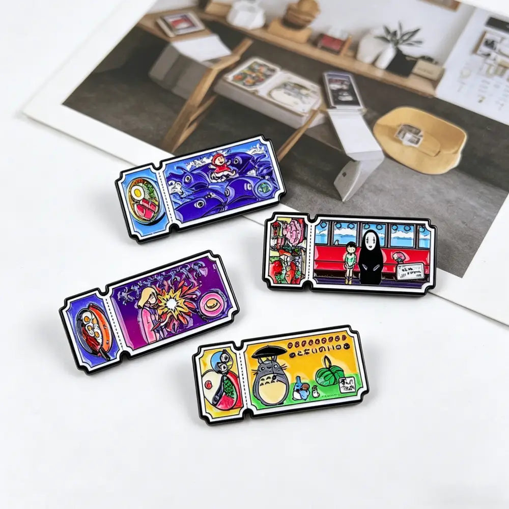 Four colorful rectangular enamel pin set featuring vintage movie ticket designs with studio ghibli illustrations