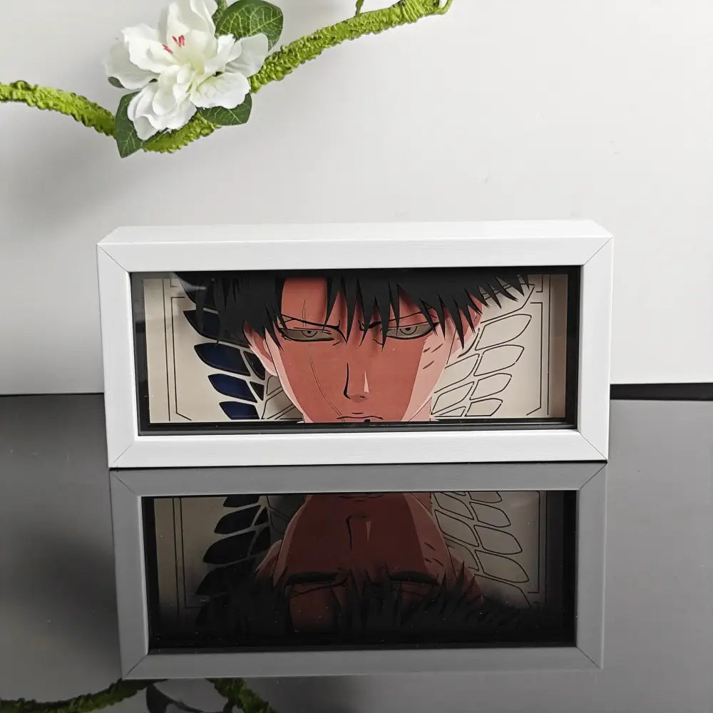 White rectangular framed anime paper cut led light box with black haired winged character encased in clear glass