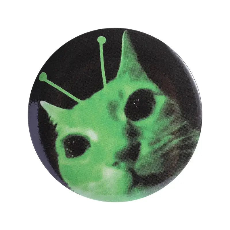 Green alien cat face anime pin brooch with glowing antennae made of durable tinplate and pin backing on black background