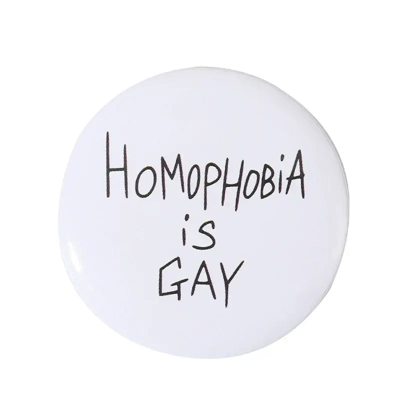 White circular anime pin brooch with durable tinplate and pin backing featuring black handwritten text homophobia is gay