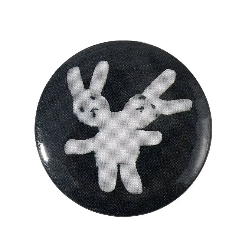 Black circular pin brooch with white embroidered rabbits featuring durable tinplate and pin backing for anime fans