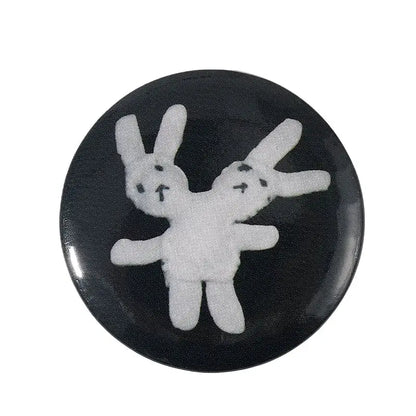 Black circular pin brooch with white embroidered rabbits featuring durable tinplate and pin backing for anime fans