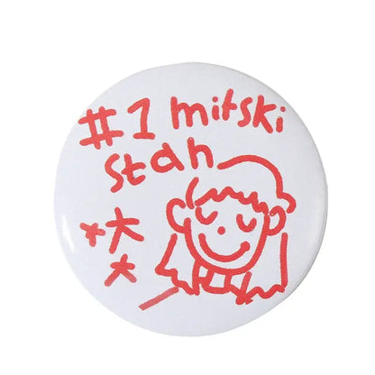 White circular pin brooch with red smiling character and text on durable tinplate featuring secure pin backing