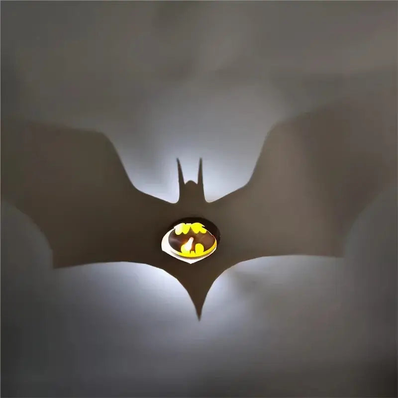 Glowing batman logo shadow projector lamp casting anime shadow of the bat symbol on the wall in a led night light